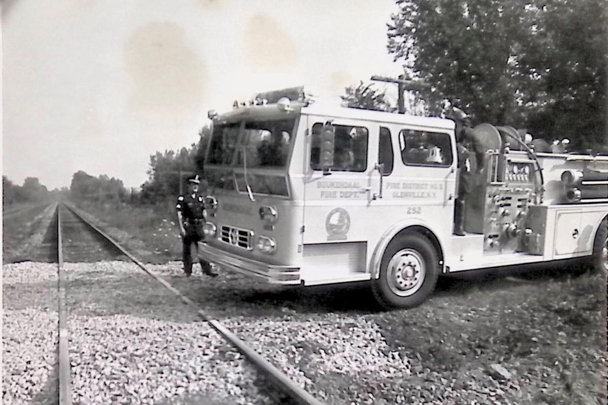 fire truck and police officer at a railroad crossing.