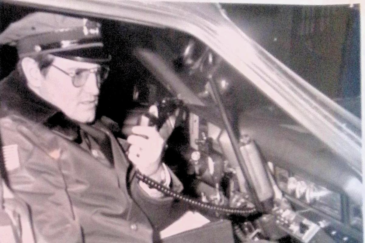 police officer seated in car with cb radio in hand
